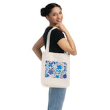 Azul Flowers Organic Canvas tote bag in natural color canvas with a print of blue azul style flowers held by a women