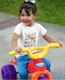 LIttle girl on a toy trike with a cozy beep t-shirt that has little cute toy cars