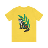 Fox tails tee that shows a black fox in front of green flora in the color yellow