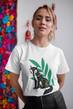 Fox tails tee that shows a black fox in front of green flora in the color white worn by a young women with a leather skirt