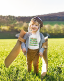 Little boy wearing a cozy little beep t shirt shirt while playing in a field