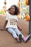 little girl wearing a cozy little beep white t-shirts while sittiing at a play ground