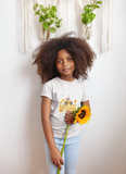 Little girl with a traveling band t-shirt that has a little car in a field of flowers