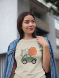 Adventure awaits t shirt in natural color that is worn by a young women walking down the street wearing a jean jacket