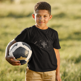 Boy wearing a black t-shirt with a cute robot on it holding a scoccer ball