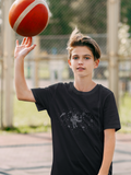 Boy wearing a black t-shirt with a robot on it holding a basketball