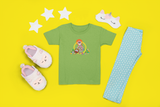 Missy Girl toddler t-shirt in green in front of a yellow backtround with slippers and stars